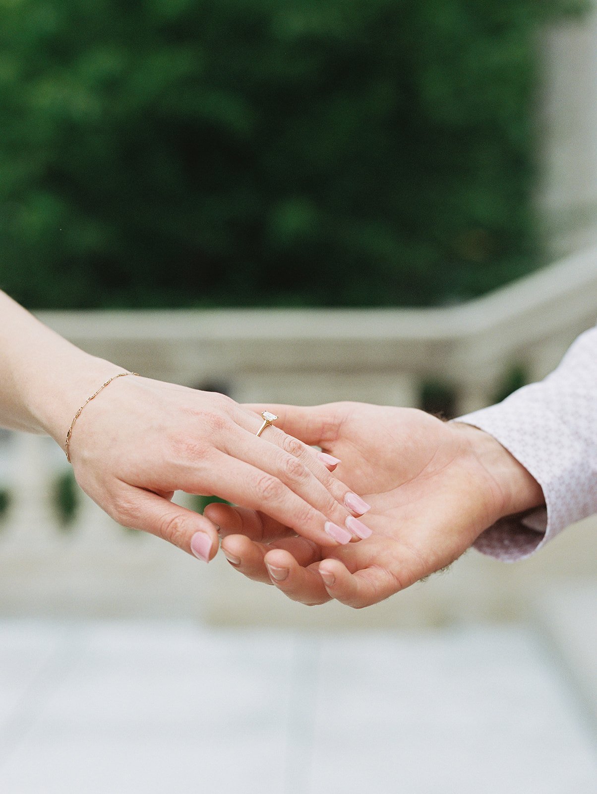 A husband holding out his hand in preparation to walk up the stairs at the Missouri Capitol for a professional photoshoot
