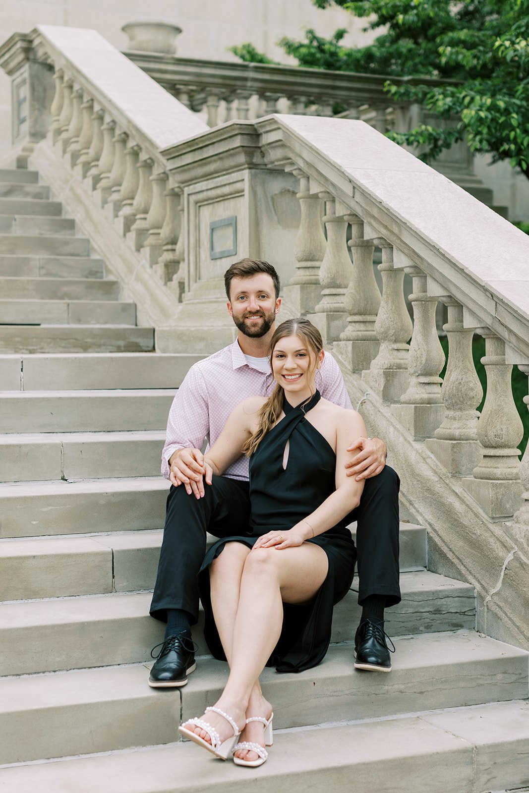 A male and female posing during their engagement session sitting on the Missouri Capitol steps