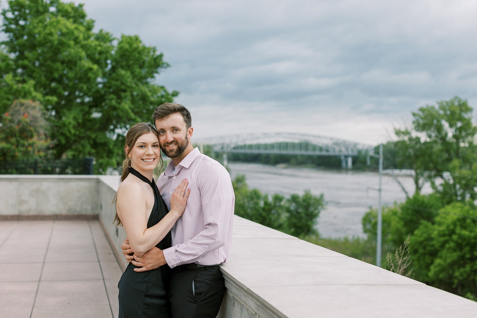 A couple standing near the Missouri Capitol with the Missouri River bridge in the background.